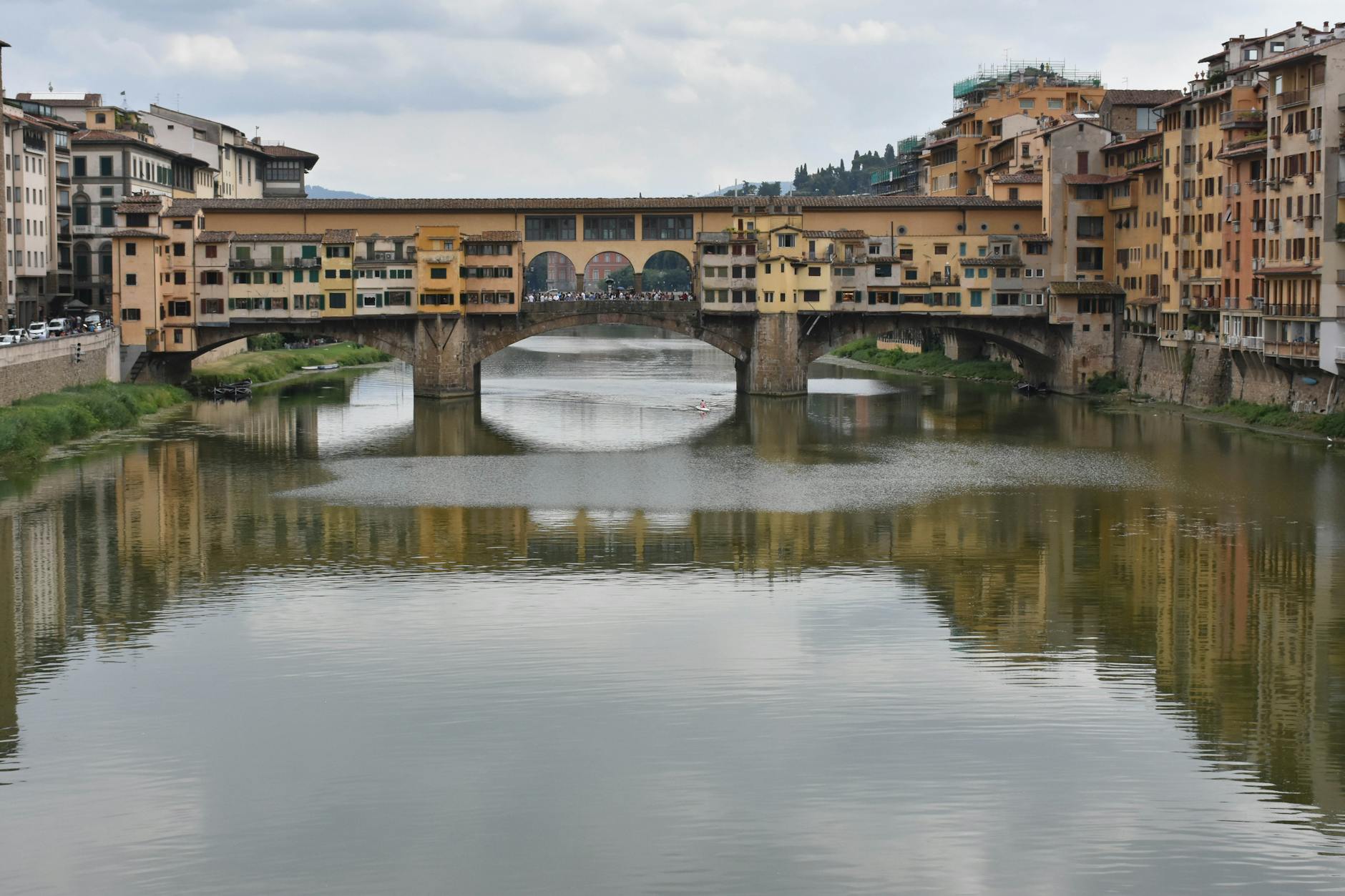 Walking across the historic Ponte Vecchio bridge over the Arno River in Florence