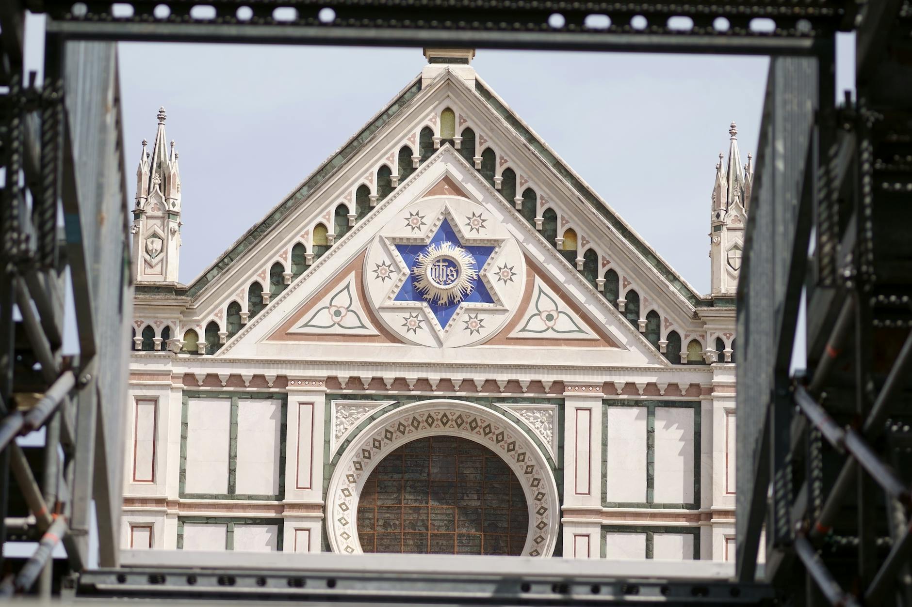 Close-up of the Basilica di Santa Croce facade in Florence, Italy, framed by scaffolding.