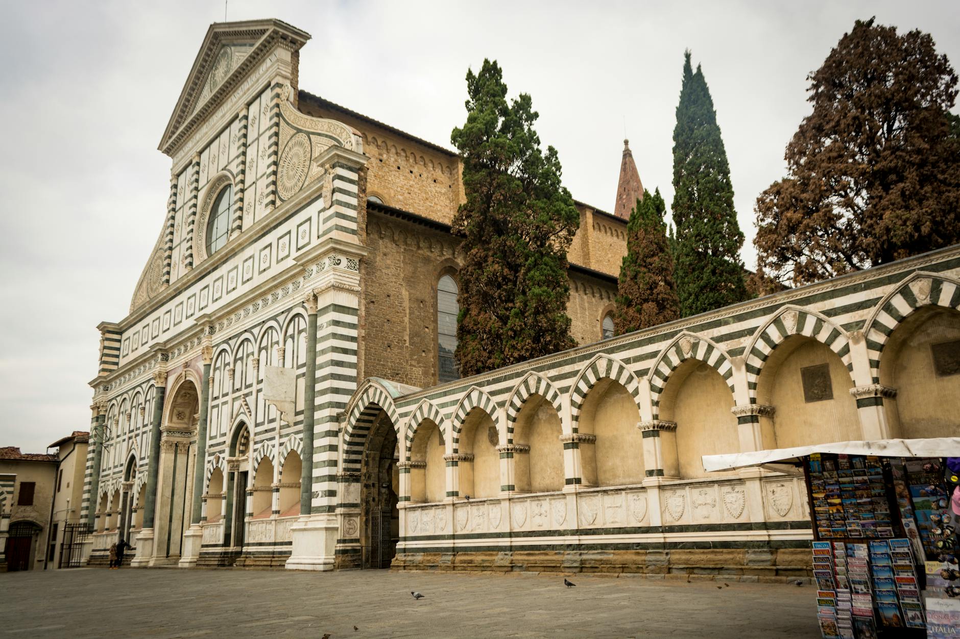 Low angle view of Santa Maria Novella's historic facade in Florence's gloomy weather.