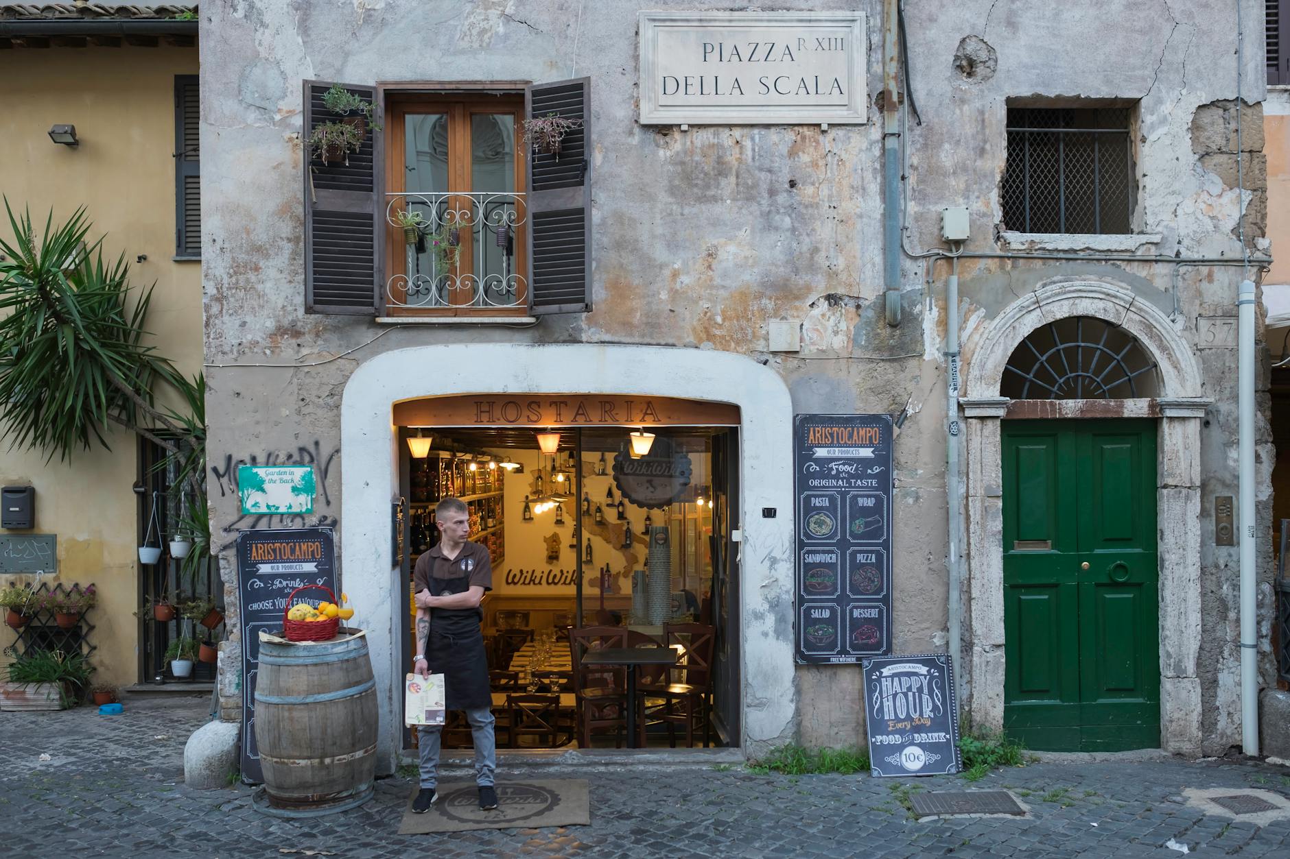 Rustic restaurant entrance in Trastevere, Rome, capturing Italian street charm.
