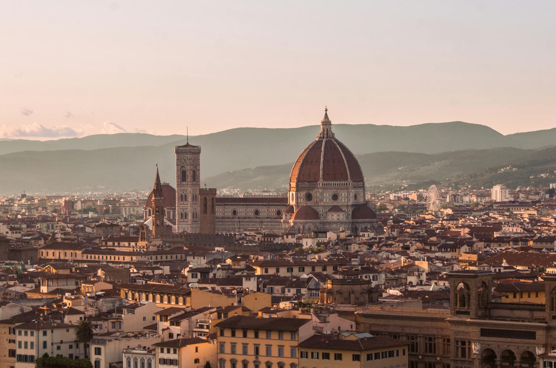 Breathtaking aerial view of Florence Cathedral and cityscape during sunset, highlighting iconic architecture.