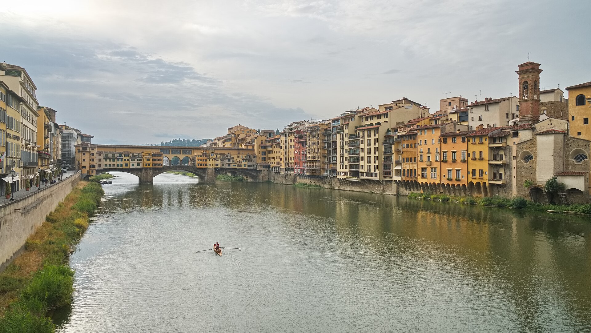 The Arno looking towards Ponte Vecchio in Florence, with the Vasari Corridor along the top of the bridge, the Oltrarno houses on the right and a sculler on the river