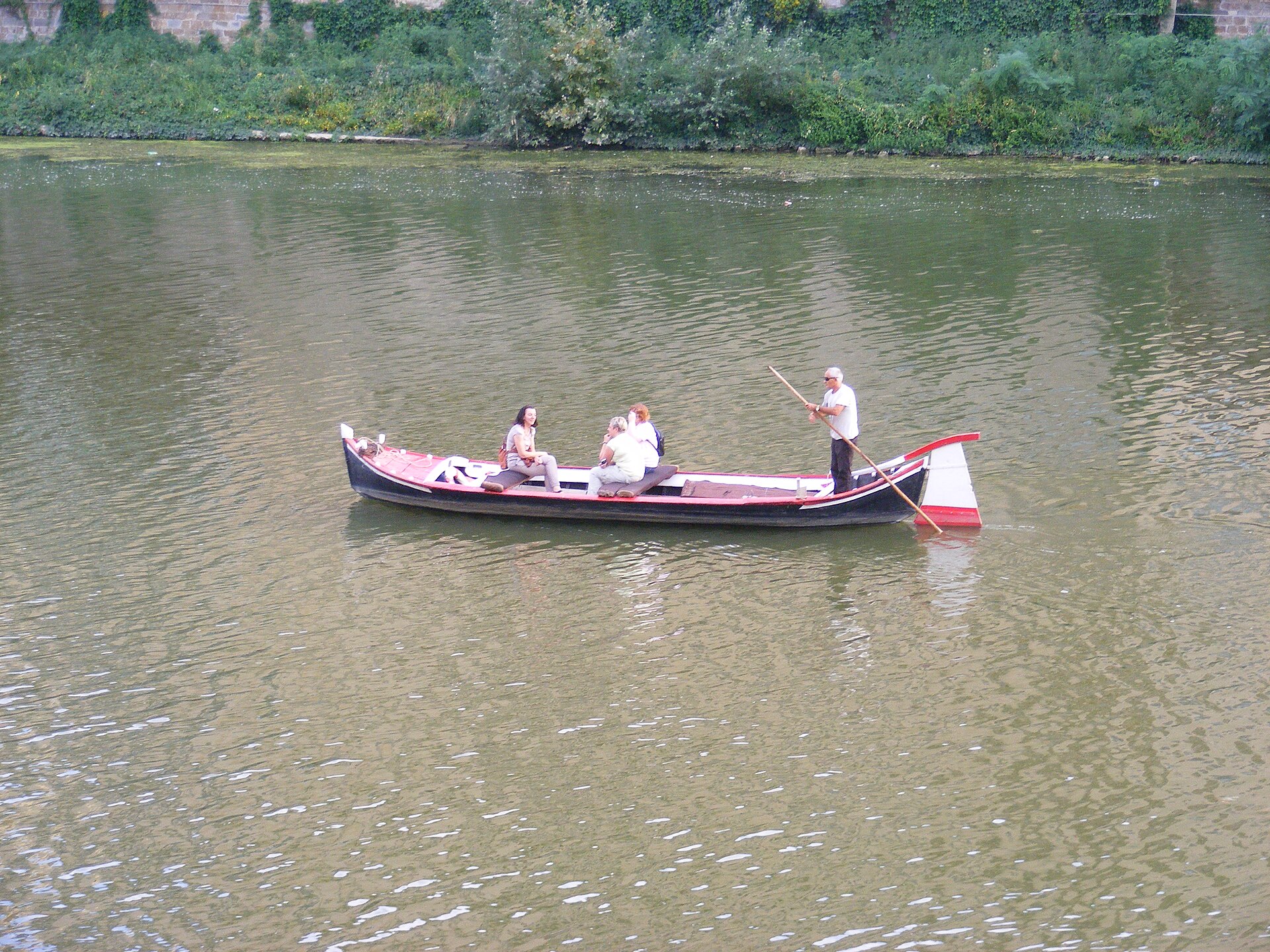 A traditional flat-bottomed barchetto boat on the Arno in Florence