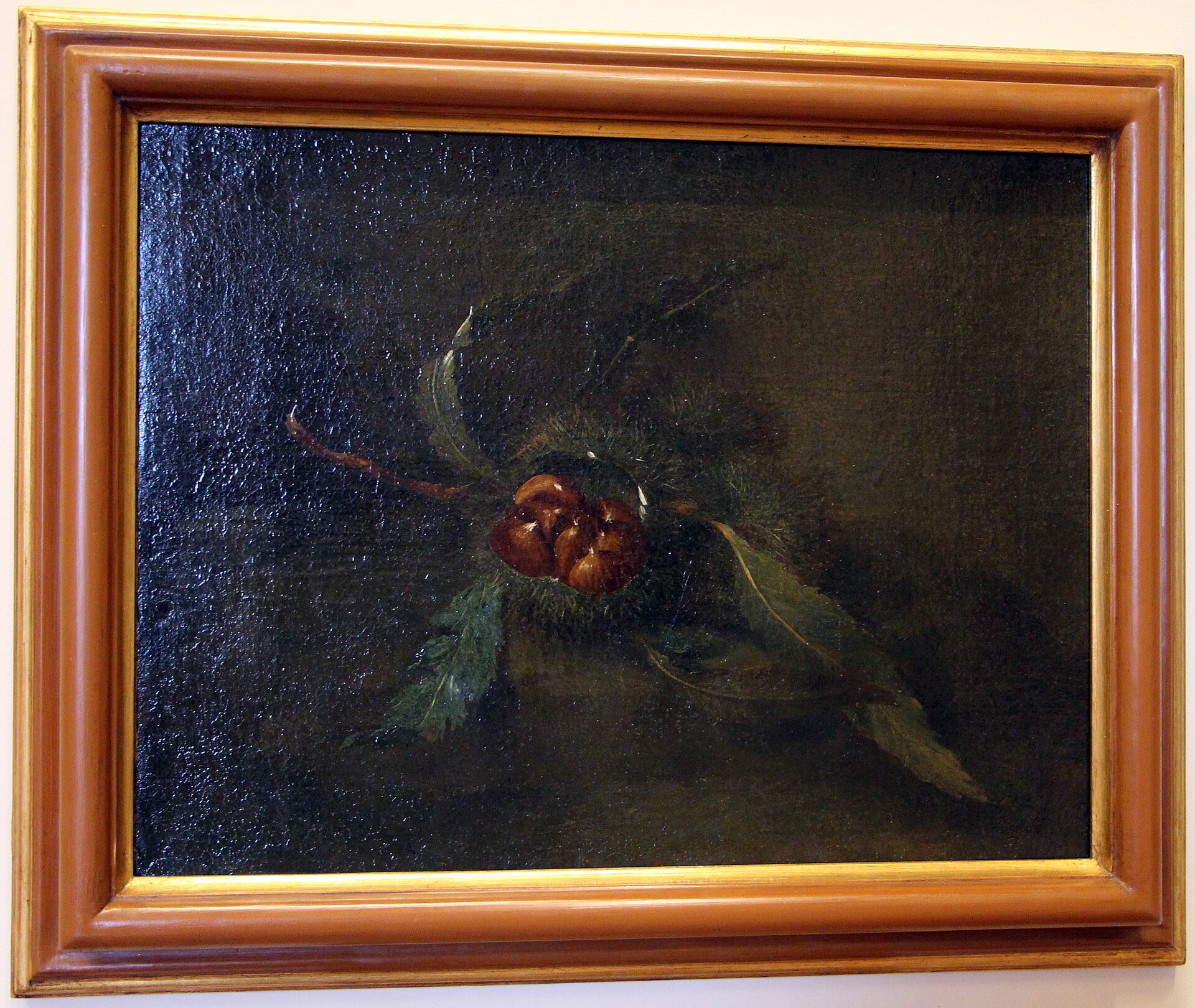 A dark oil painting in a gilt frame showing a branch of sweet chestnut with an open spiny burr and three glossy brown marroni