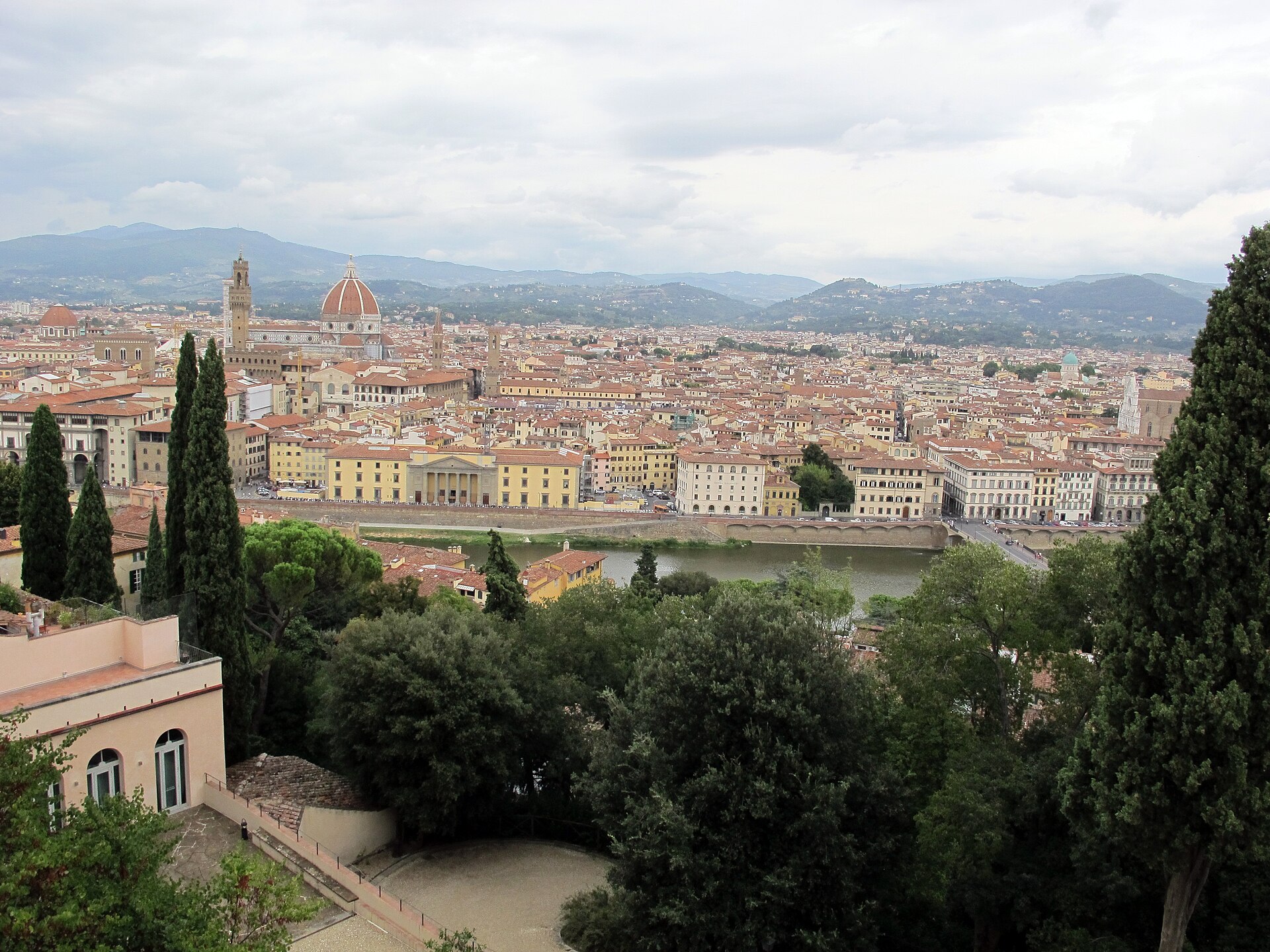 View over Florence from the Bardini hillside, with the Arno, the Duomo and Palazzo Vecchio's tower above the rooftops and the hills beyond