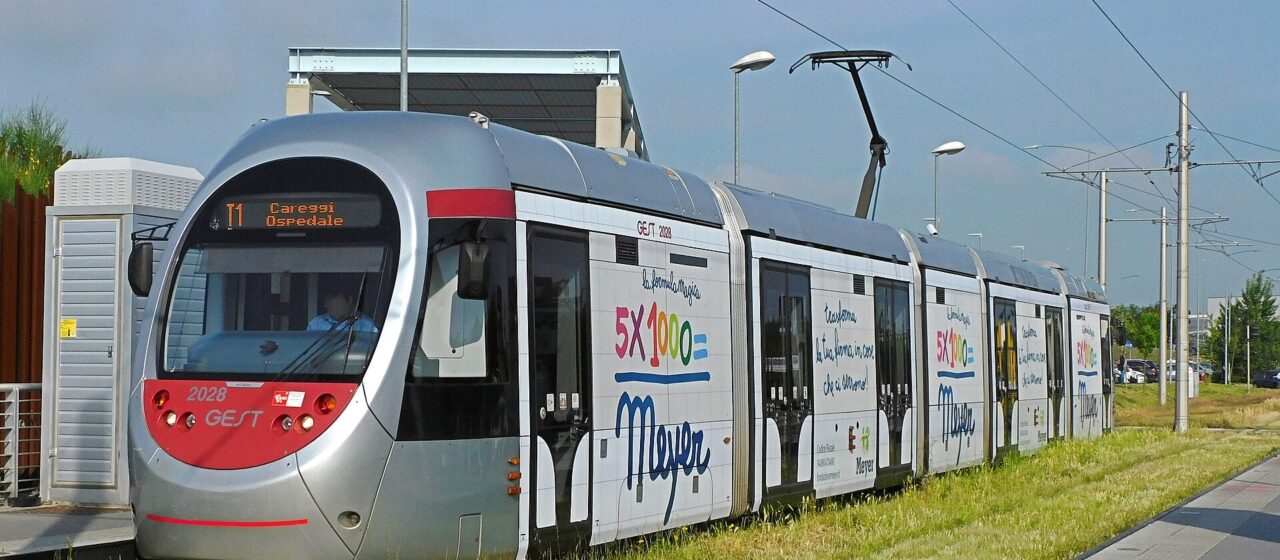 A silver Florence T1 tram at the Villa Costanza terminus, signed for Careggi Ospedale, standing on a grassed track beside a platform