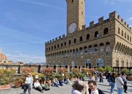 Visitors on the Uffizi rooftop terrace in Florence with Palazzo Vecchio behind