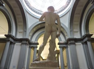 Michelangelo's David seen from behind beneath the domed skylight of the purpose-built tribune in the Accademia Gallery