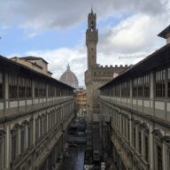 The Piazzale degli Uffizi courtyard in Florence seen from above, with Palazzo Vecchio's tower and the Duomo beyond
