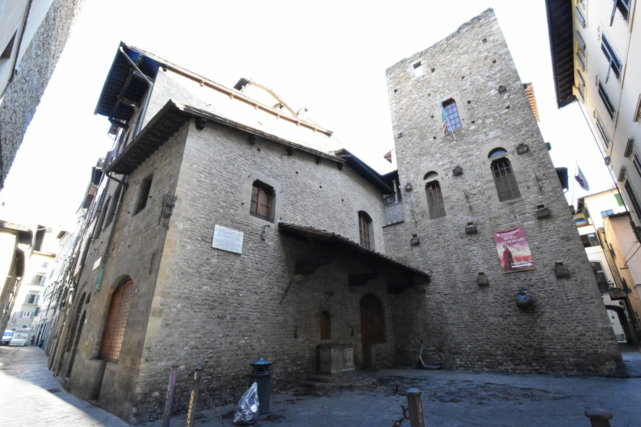Casa di Dante’s stone walls, projecting tiled roof and square tower enclose a small paved courtyard in Florence.