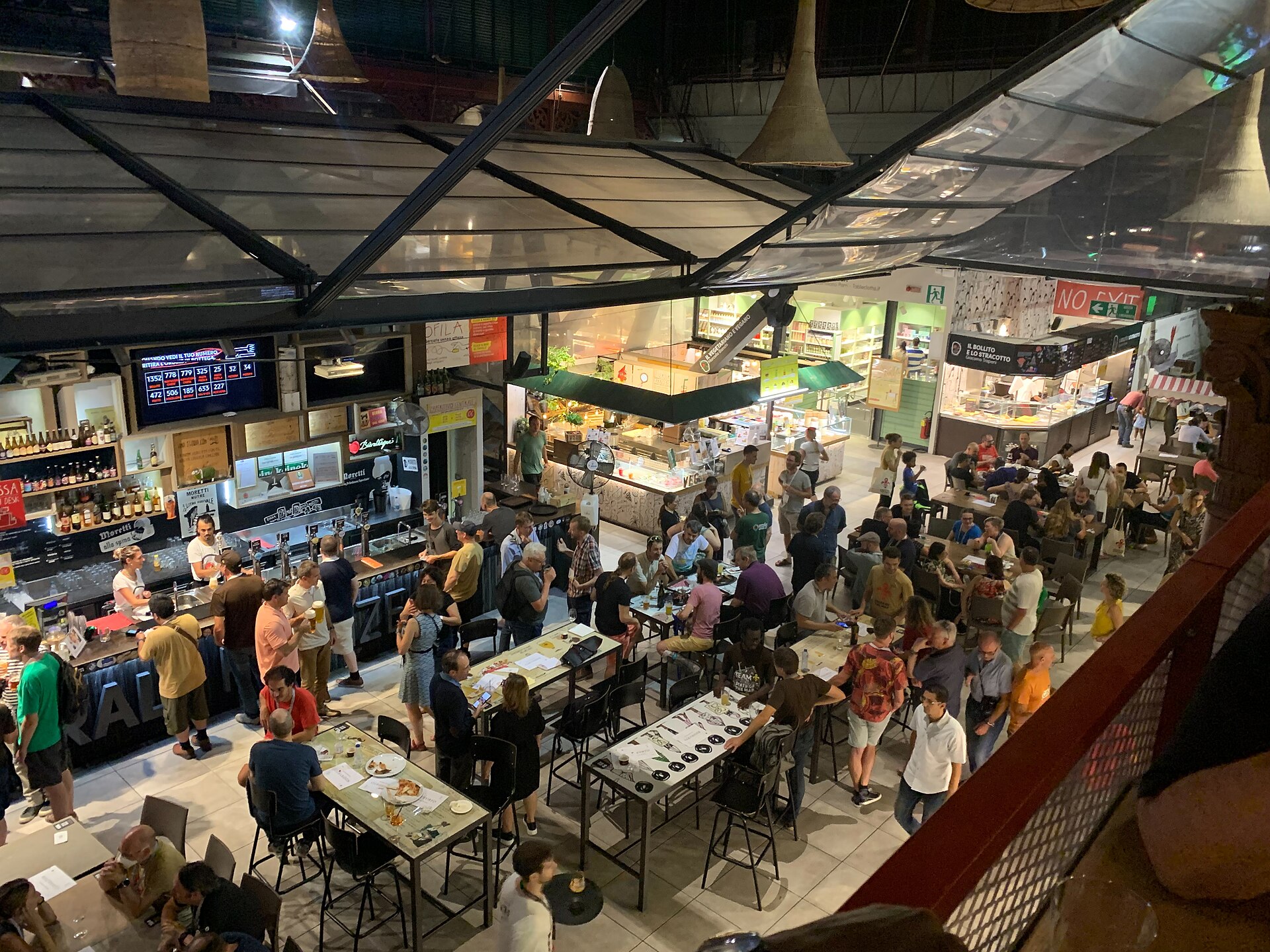 An elevated view overlooks diners, communal tables and food counters in the upstairs hall of Florence's Mercato Centrale.