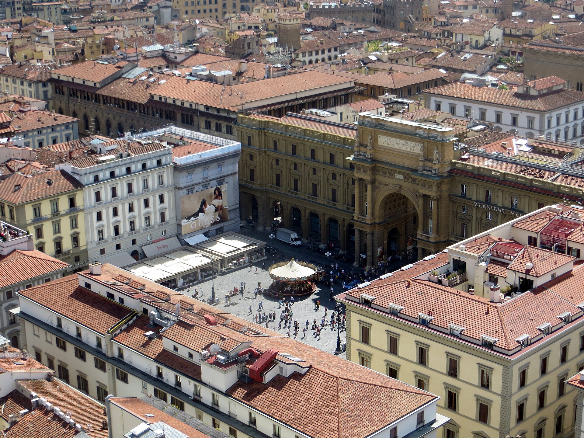Florence’s Piazza della Repubblica lies among terracotta rooftops, with visitors gathered near its carousel and monumental arch.