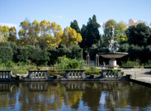 Golden trees and the Oceanus fountain reflect in the pond surrounding the Isolotto in Florence’s Boboli Gardens.