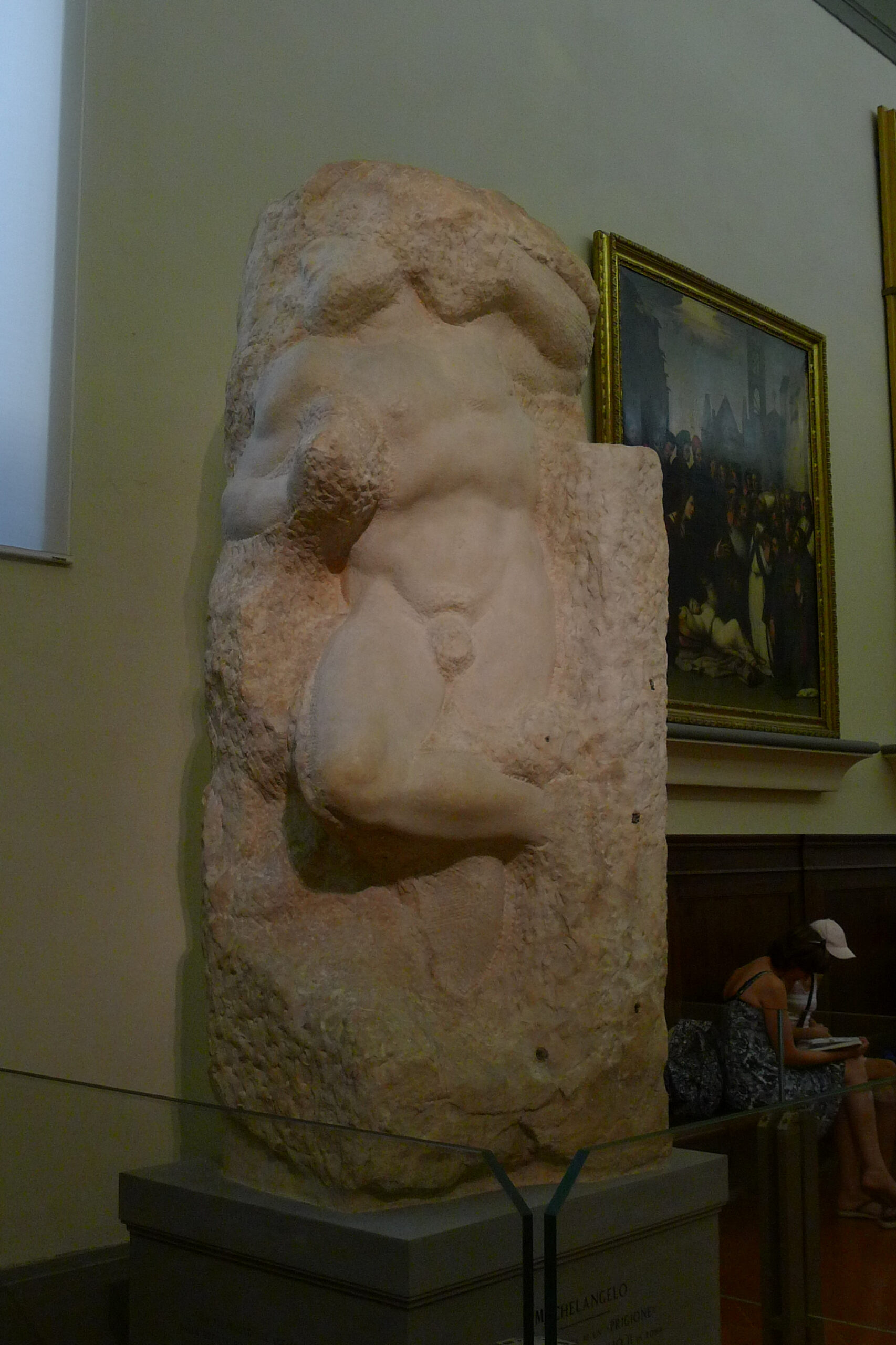 Michelangelo's unfinished Awakening Slave emerges from rough marble on a plinth inside Florence's Galleria dell'Accademia.