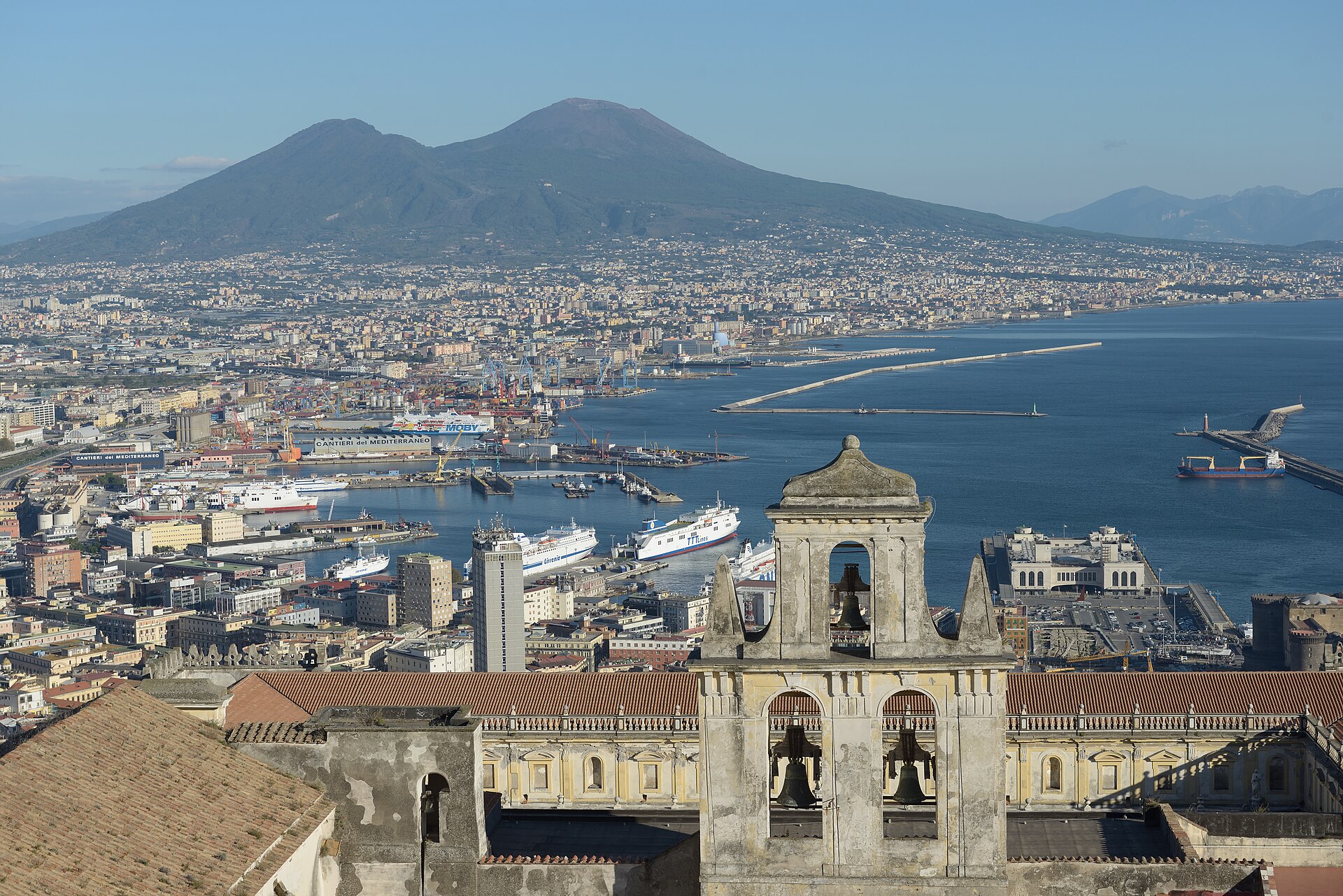 Naples seen from the hill of Sant'Elmo, with the bell tower of the Certosa di San Martino in front, the port and bay in the middle and Vesuvius behind