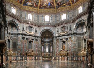 Patterned stone floors and richly coloured walls rise beneath the painted dome of the Princes' Chapel in Florence.