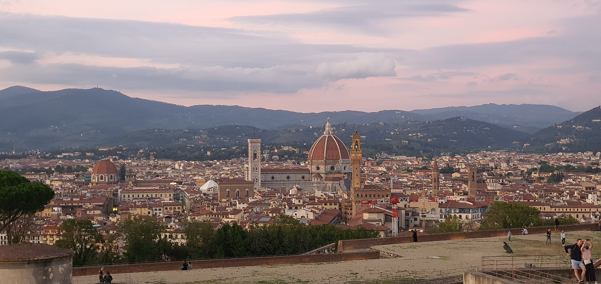 Pink evening clouds hang above Florence’s Duomo and Palazzo Vecchio, seen across the terraces of Forte Belvedere.