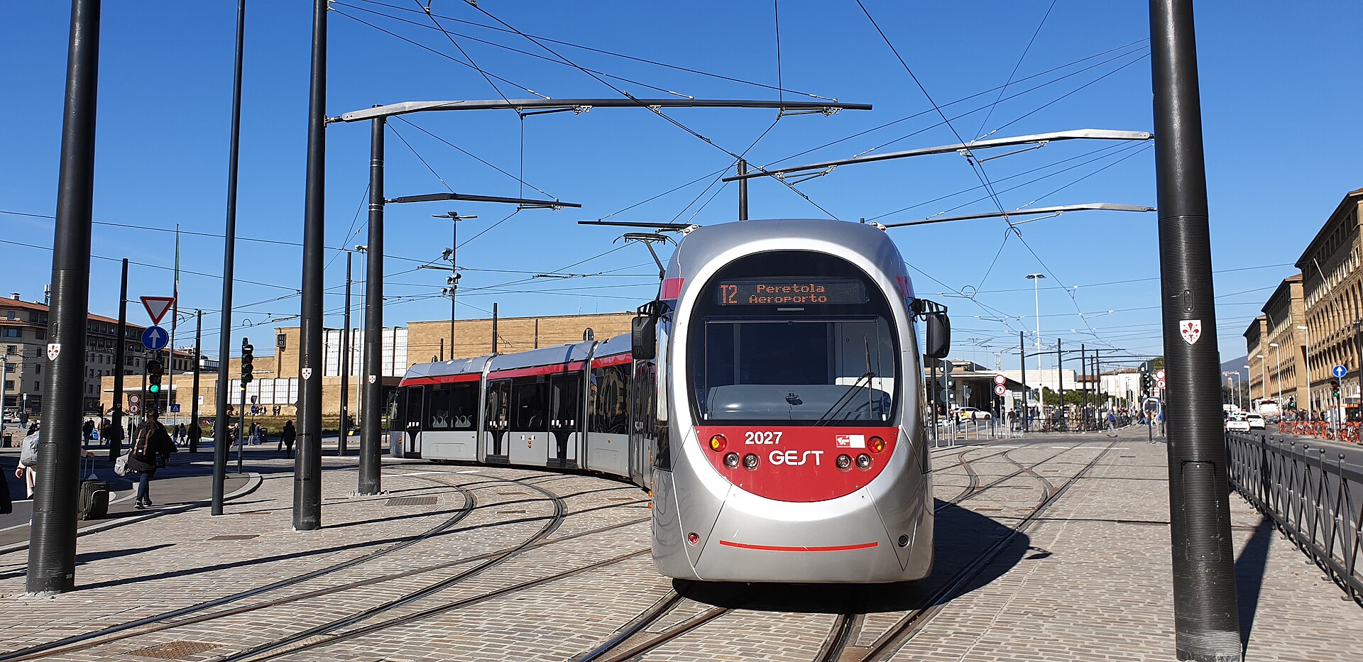 A silver and red T2 tram displays Peretola aeroporto beside Florence’s Santa Maria Novella station.
