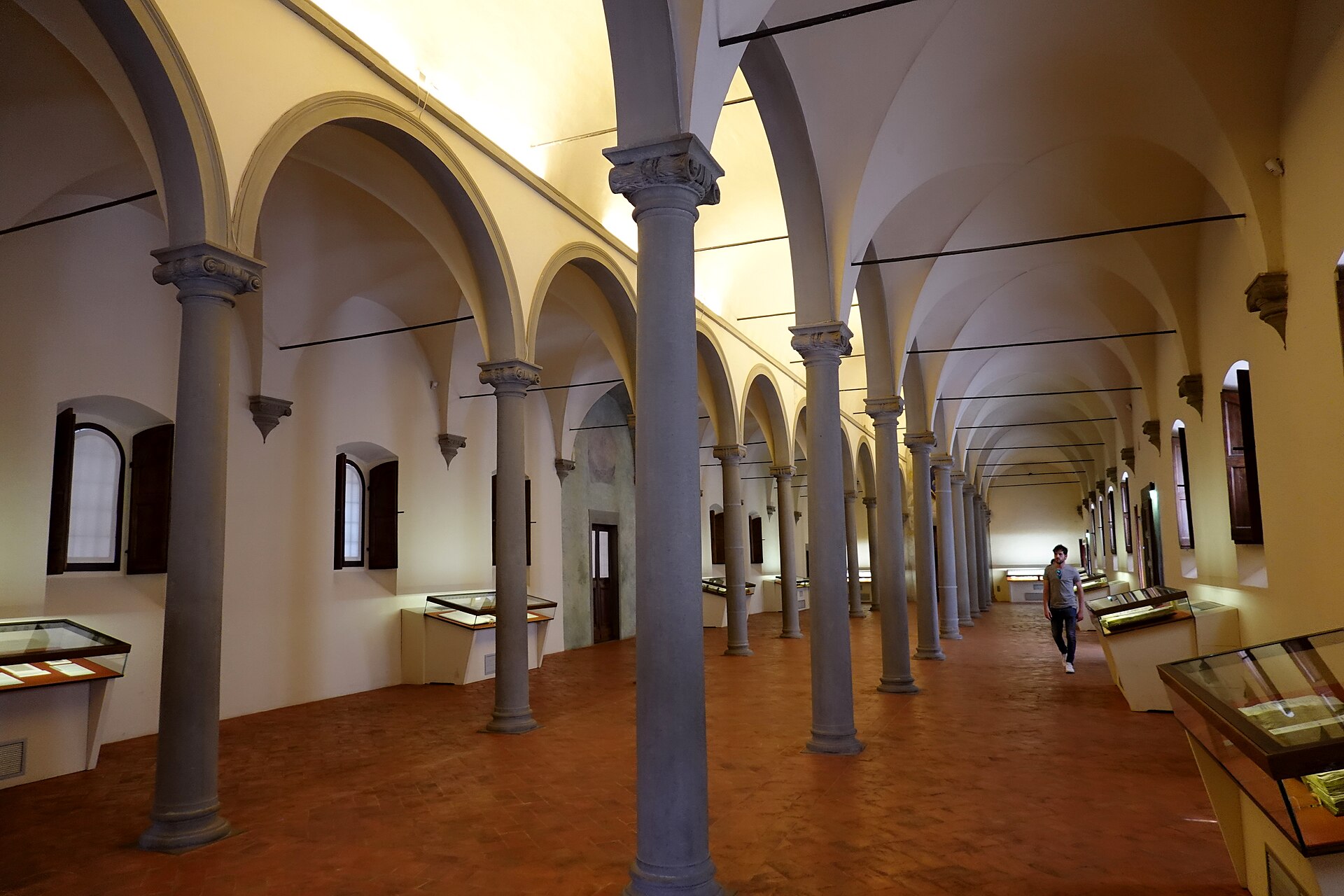 Slender columns divide Michelozzo's library at Florence's San Marco into vaulted aisles lined with glass display cases.