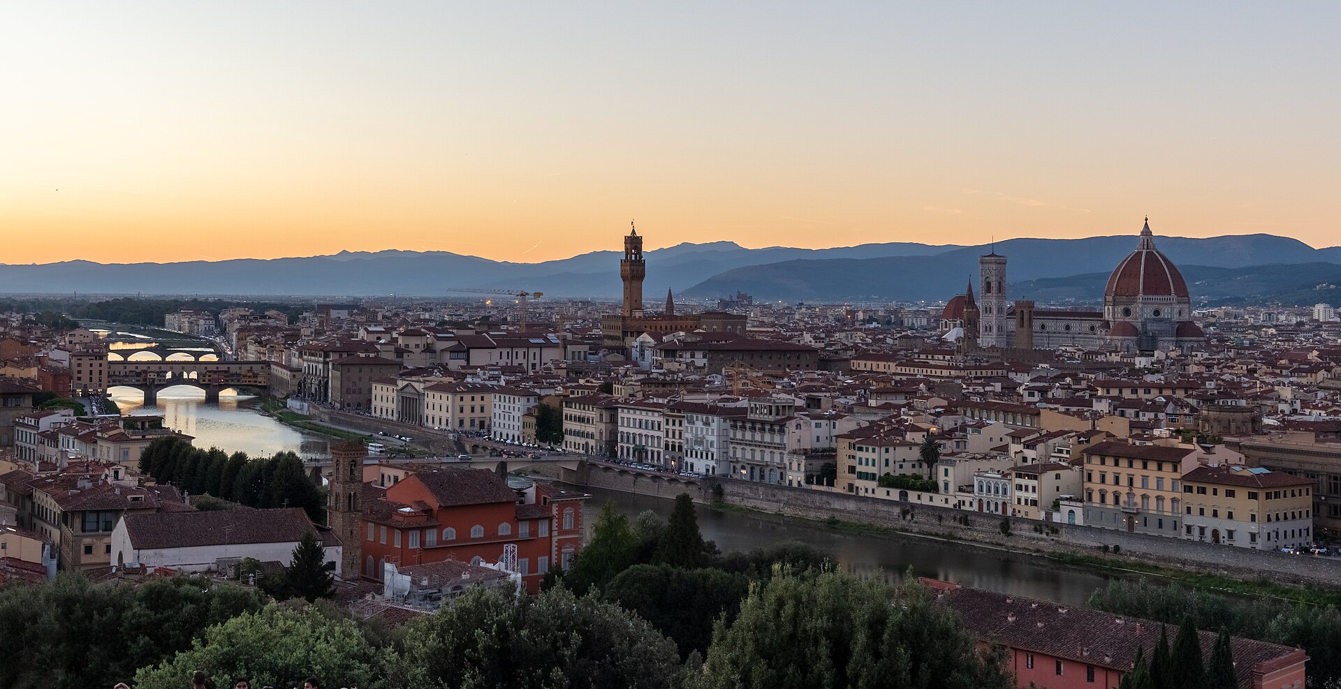 Sunset colors the horizon behind Florence’s Arno, Ponte Vecchio, Palazzo Vecchio and cathedral, seen from Piazzale Michelangelo.