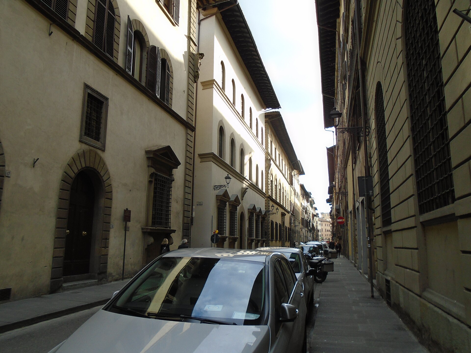 Tall palazzi, arched doorways and shuttered windows line Via Maggio in Florence’s Oltrarno, beside parked cars.